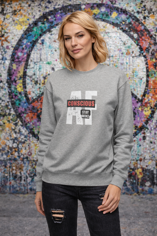 Person wearing a gray sweatshirt with text in front of a colorful mosaic wall.